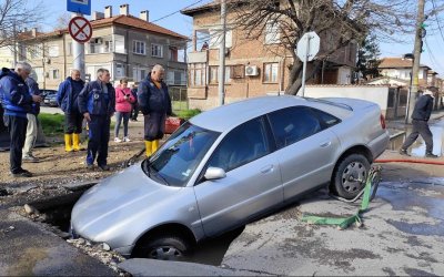 Кошмар на пътя: Кола пропадна в огромна дупка на наводнена улица в Пловдив (СНИМКИ)